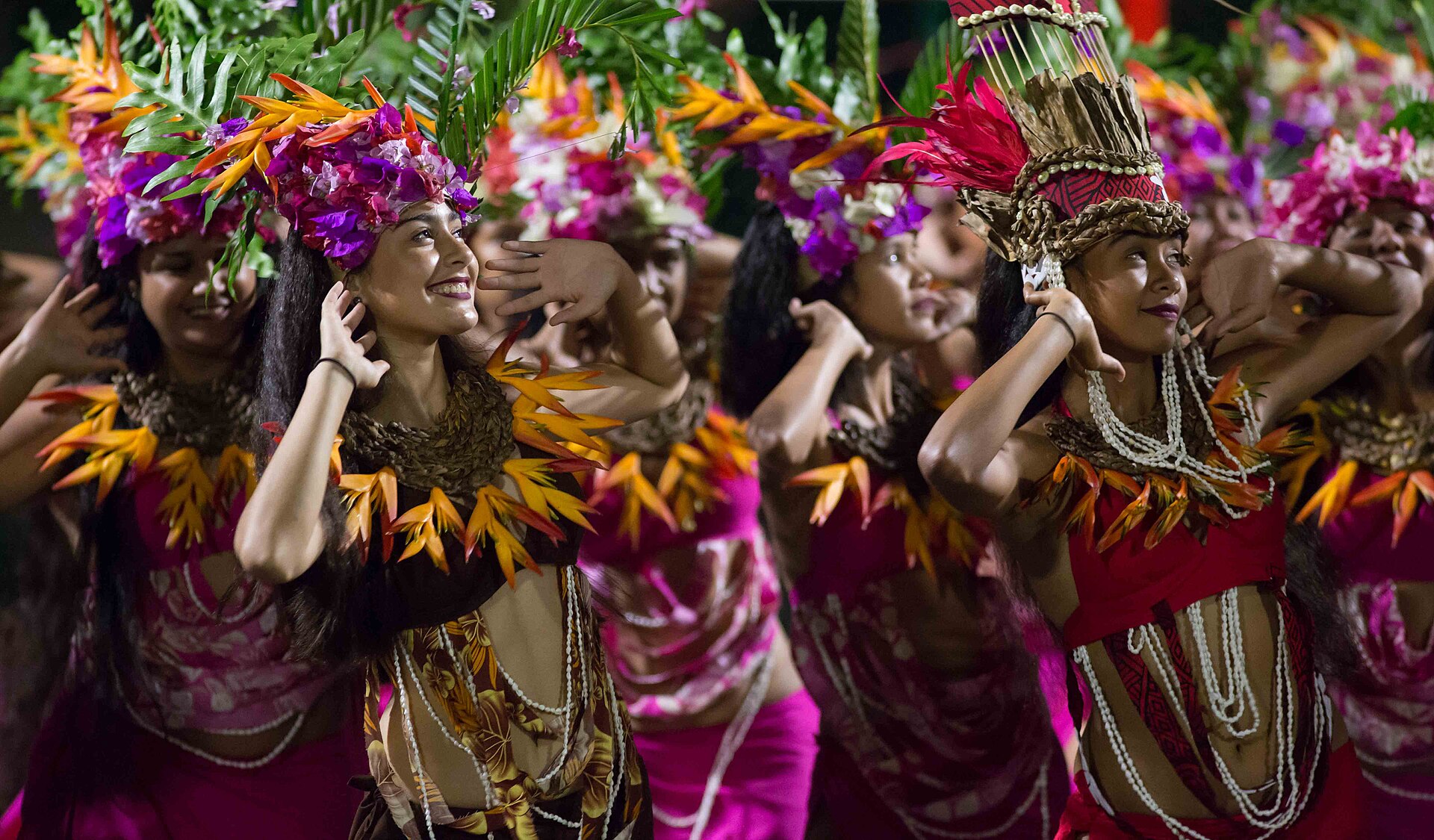 Heiva dancers in flower crowns mid-performance