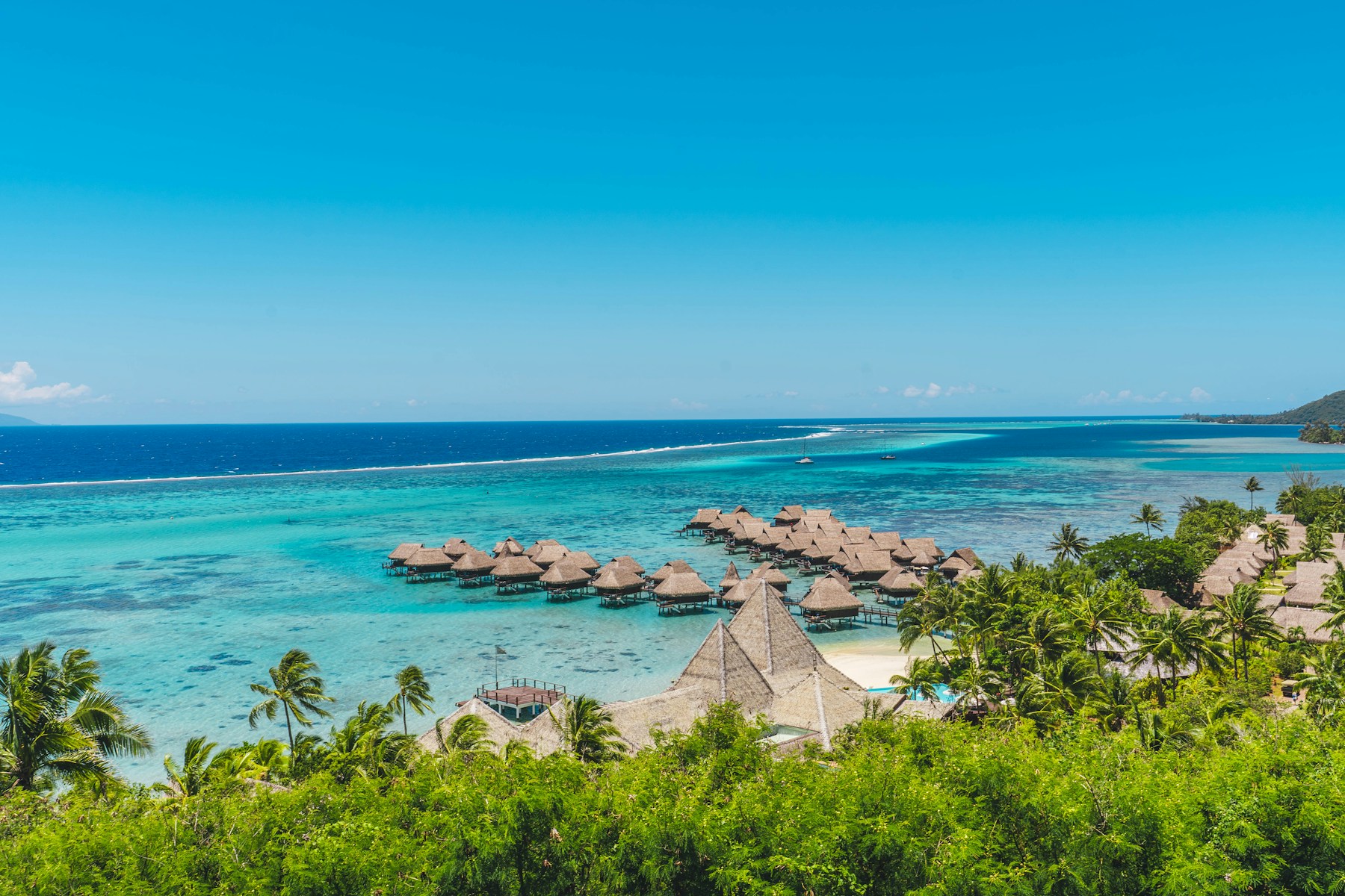 Thatched overwater bungalows beside a Moorea beach