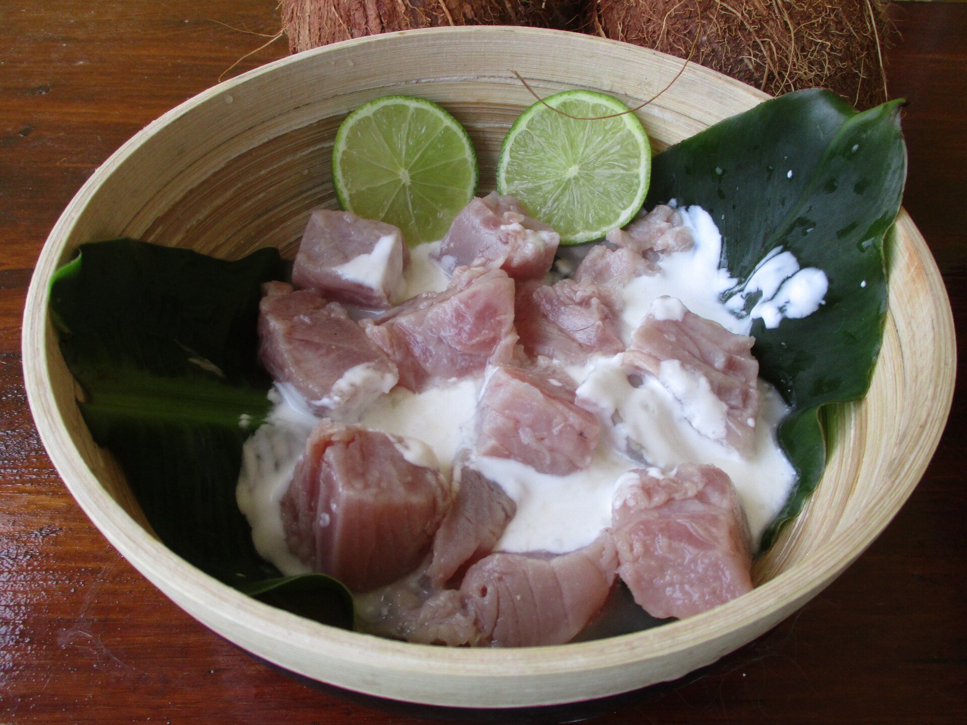 A bowl of poisson cru with lime and coconut milk