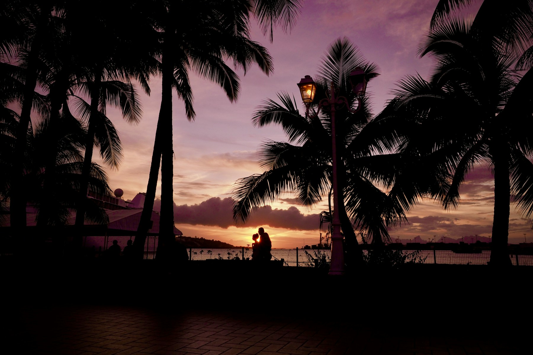People gathering on the Tahitian shore at sunset